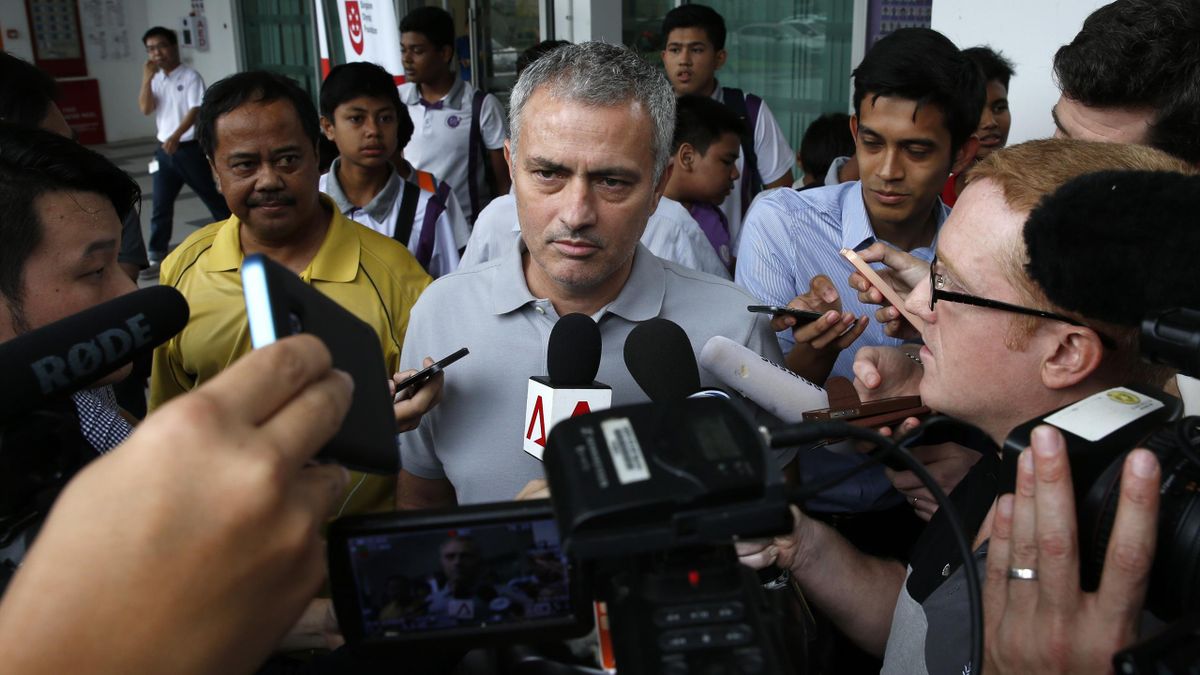 Former Chelsea manager Jose Mourinho (C) speaks to the media after a visit to NorthLight School in Singapore