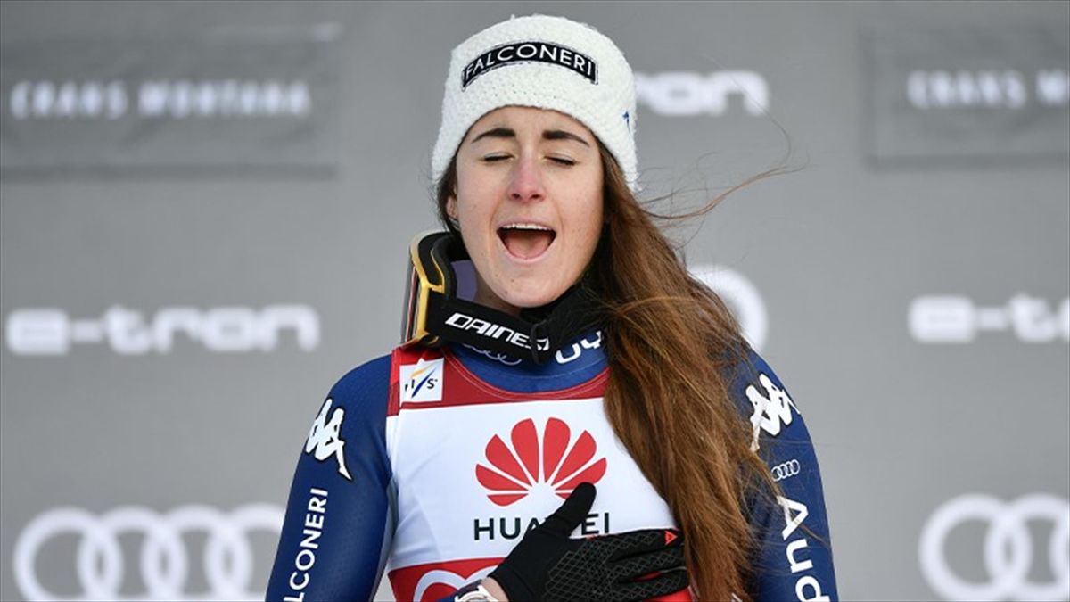 Winner Italy's Sofia Goggia sings her National Anthem as she celebrates on the podium after the Women's Downhill event at the FIS Alpine Ski World Cup in Crans-Montana