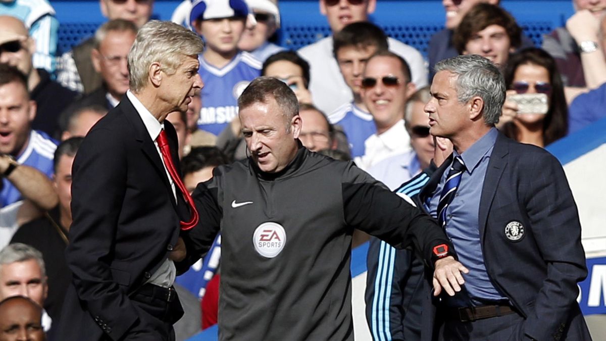 Chelsea's Portuguese manager Jose Mourinho (R) and Arsenal's French manager Arsene Wenger (L) are kept apart by the fourth official Jonathan Moss during the English Premier League football match between Chelsea and Arsenal at Stamford Bridge in London on