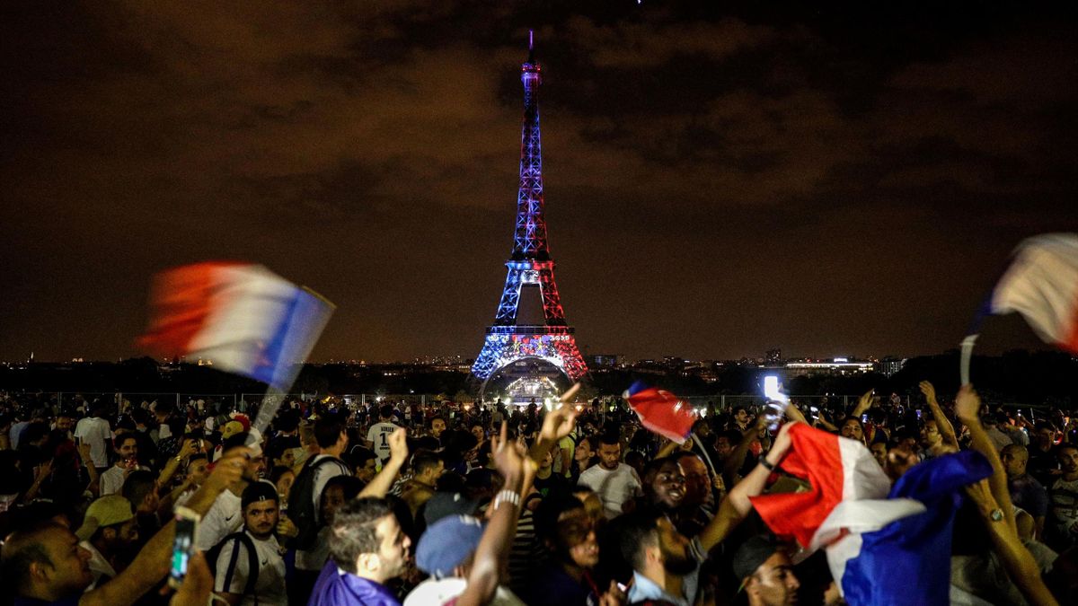 TOPSHOT - This picture taken from Trocadero on July 15, 2018 shows the Eiffel Tower illuminated in French national colors during celebrations after the Russia 2018 World Cup final football match between France and Croatia, on the Champs-Elysees avenue in