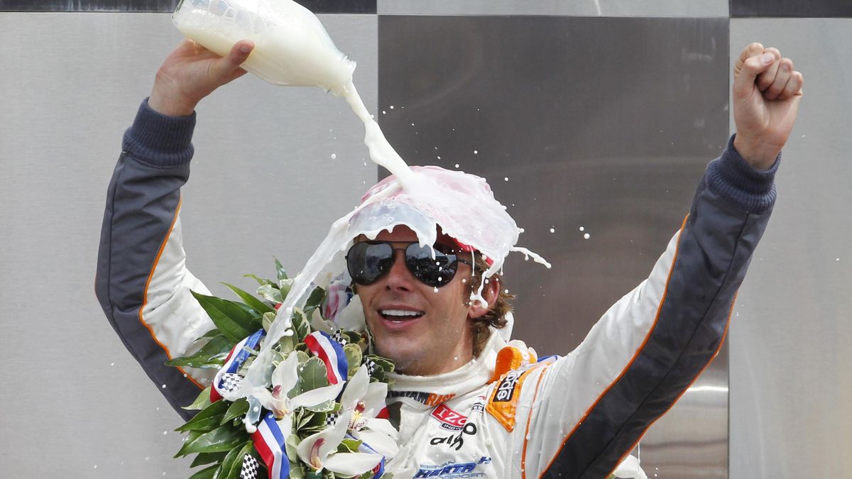 Dan Wheldon of England celebrates while pouring the traditional milk on his head after winning the
