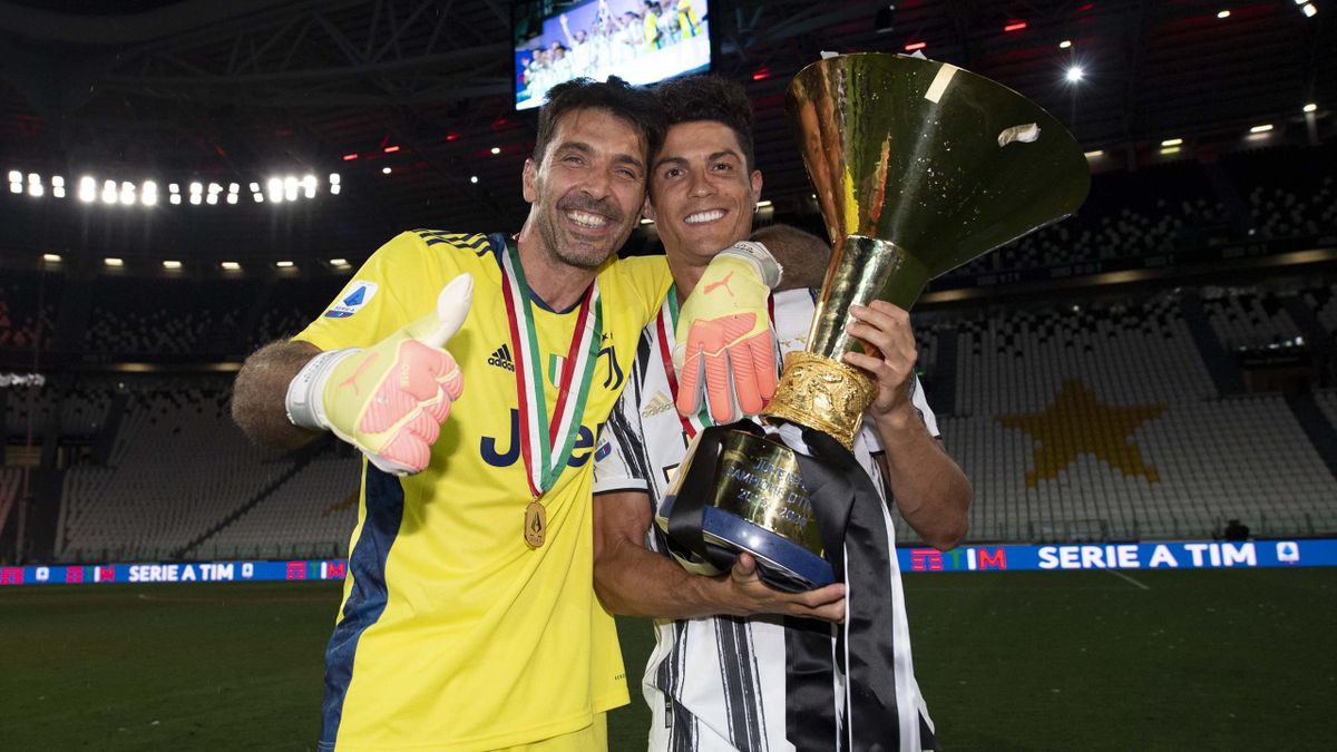 Gianluigi Buffon and Cristiano Ronaldo of Juventus celebrate winning the Italian championship "scudetto" 2019-2020 (ninth title in a row) with the trophy after the Serie A match between Juventus and AS Roma at Allianz Stadium on August 01, 2020 in Turin