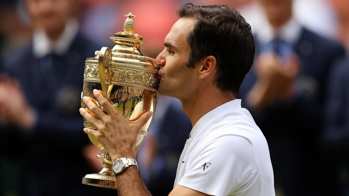 Roger Federer of Switzerland kisses the trophy as he celebrates victory