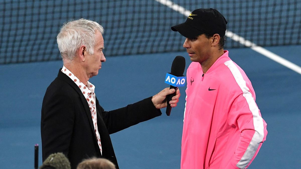 Spain's Rafael Nadal speaks with former US tennis player John McEnroe after his victory against Australia's Nick Kyrgios during their men's singles match on day eight of the Australian Open tennis tournament in Melbourne on January 27, 2020.