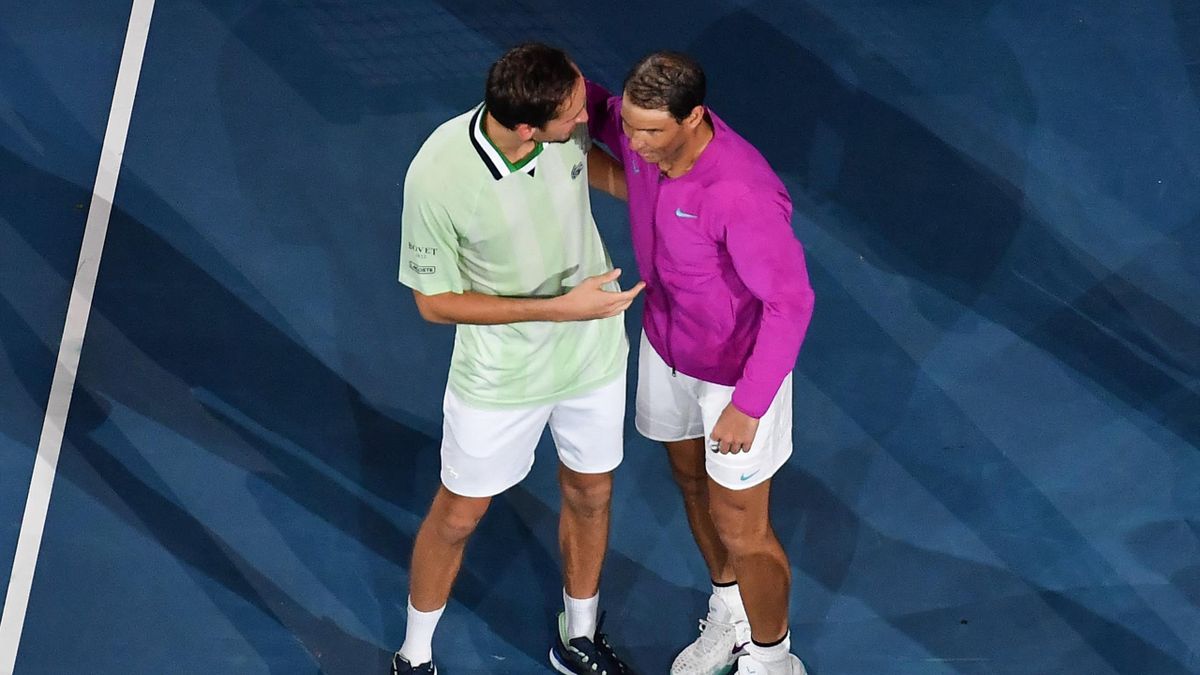 Spain's Rafael Nadal (R) talks with Russia's Daniil Medvedev after winning the men's singles final match on day fourteen of the Australian Open tennis tournament in Melbourne early on January 31, 2022.