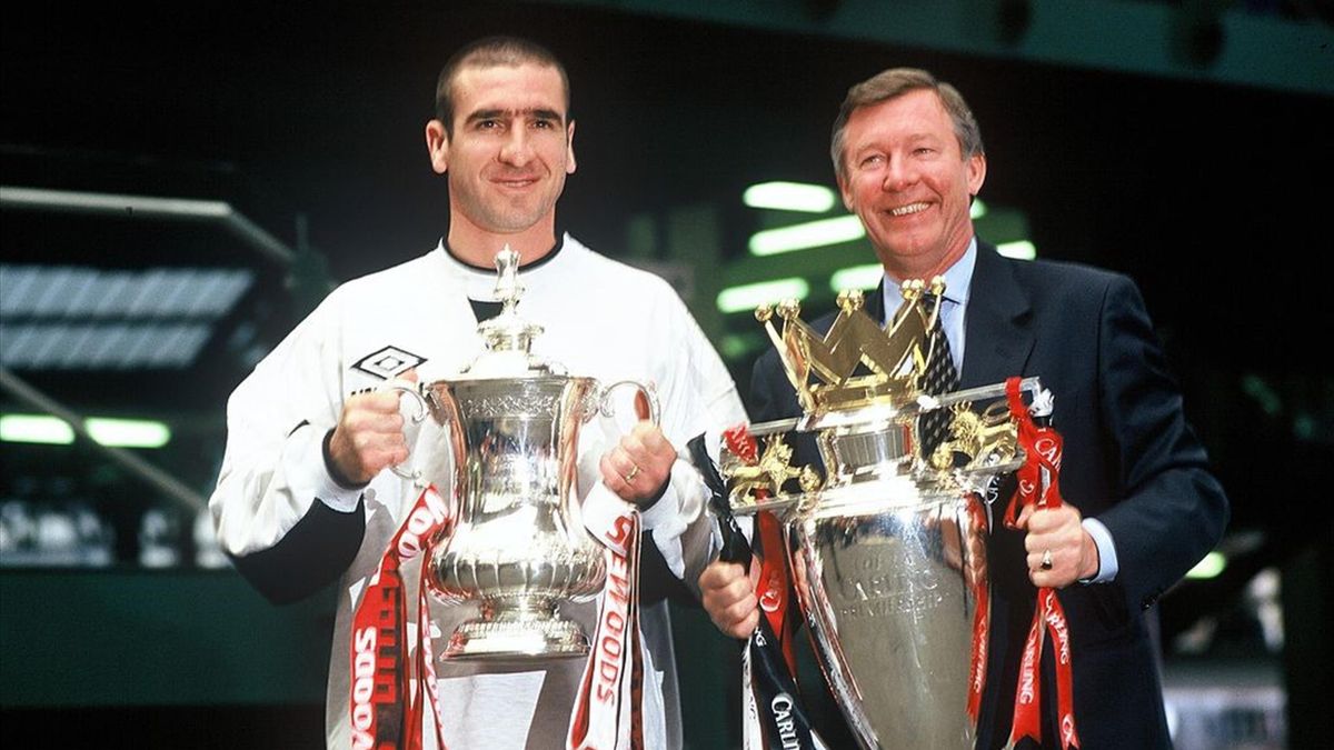 Manchester United manager Alex Ferguson and Eric Cantona with the FA Cup and Premiership trophy on their arrival at Manchester's Victoria station.