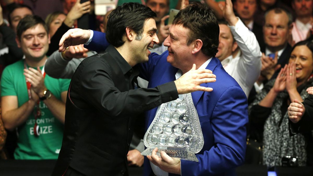 Jimmy White presents Ronnie O'Sullivan with the Masters trophy after victory in the 2016 final.