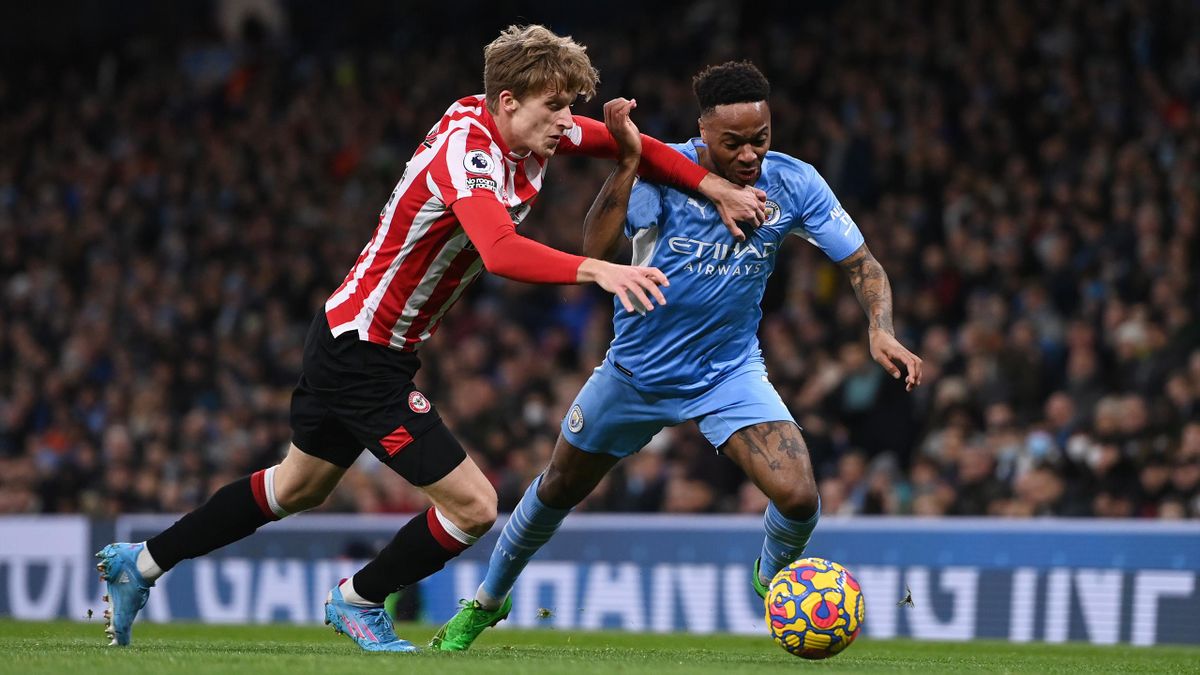 Raheem Sterling of Manchester City is challenged by Mads Roerslev of Brentford during the Premier League match between Manchester City and Brentford at Etihad Stadium on February 09, 2022 in Manchester, England. (Photo by Gareth Copley/Getty Images)