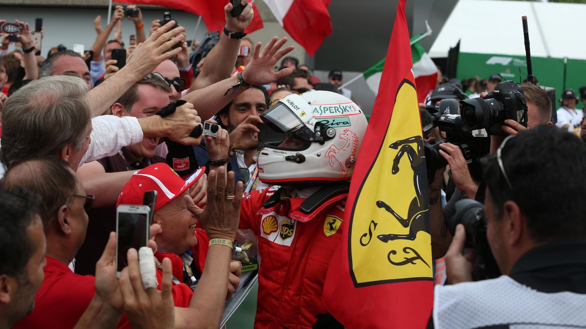 Sebastian Vettel festeggia con la bandiera della Ferrari