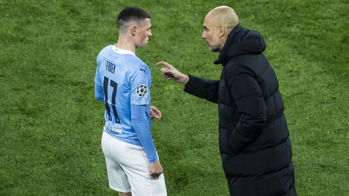 Head coach Josep Guardiola (R) and Phil Foden during the UEFA Champions League Quarter Final Second Leg match between Borussia Dortmund and Manchester City at Signal Iduna Park on April 14, 2021 in Dortmund, Germany.