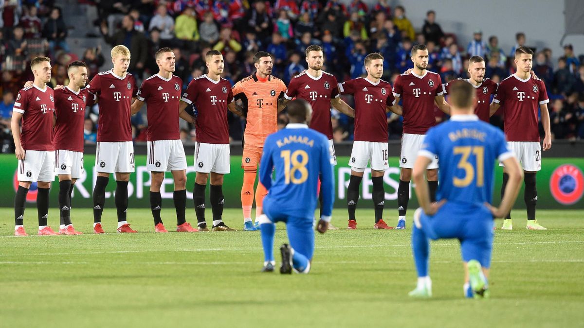 Sparta Prague's players stand while Rangers' Finnish midfielder Glen Kamara (front L) and Rangers' Croatian defender Borna Barisic take the knee prior to the start of the UEFA Europa League Group A football match between AC Sparta Praha and Rangers FC
