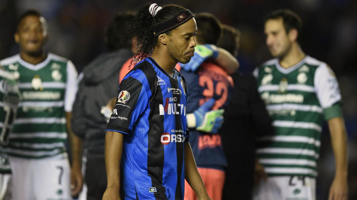 Ronaldinho (C) of Queretaro walkson the field after losing against Santos in their Mexican Clasura 2015 tournament final in Queretaro, Mexico, on May 31, 2015
