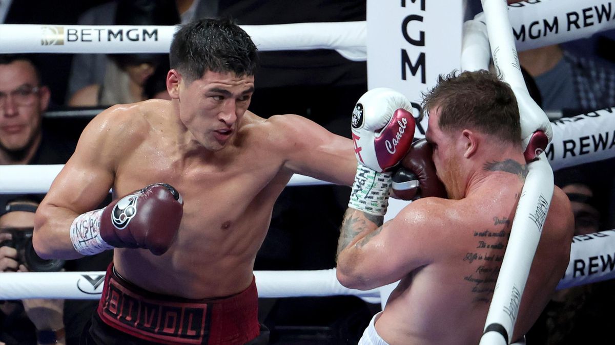 Dmitry Bivol (L) hits Canelo Alvarez with a left in the fifth round of their WBA light heavyweight title fight