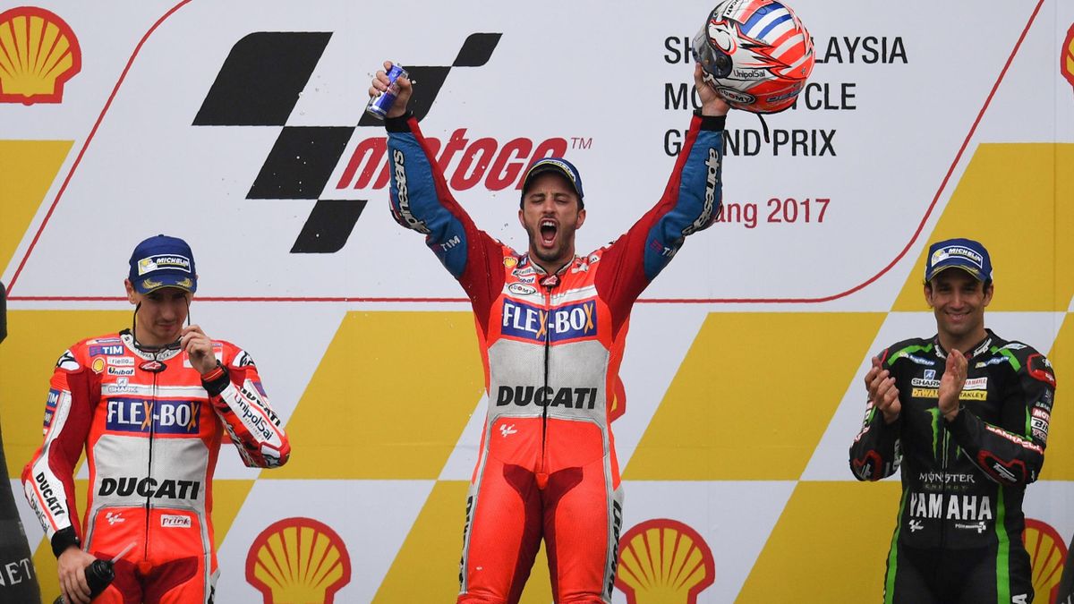 Ducati Team's Italian rider Andrea Dovizioso (C) celebrates on the podium after winning the Malaysia MotoGP next to second-placed Ducati Team's Spanish rider Jorge Lorenzo (L) and third-placed Monster Yamaha Tech 3 French rider Johann Zarco at the Sepang