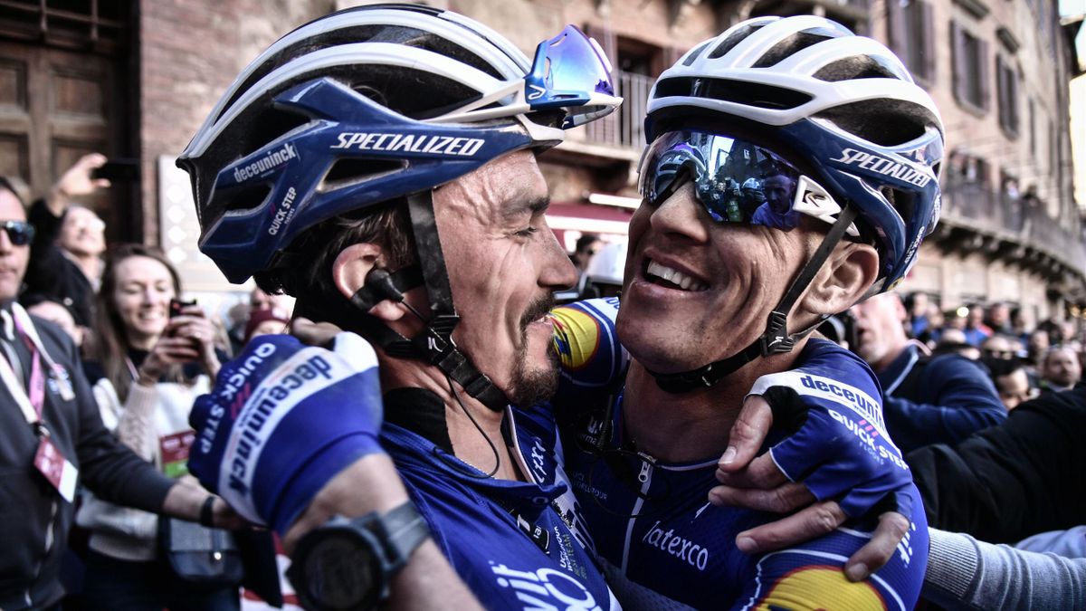 France's Julian Alaphilippe (L) embraces Czech teammate Zdenek Stybar after winning the one-day classic cycling race Strade Bianche (White Roads) on March 9, 2019 in Siena, Tuscany.