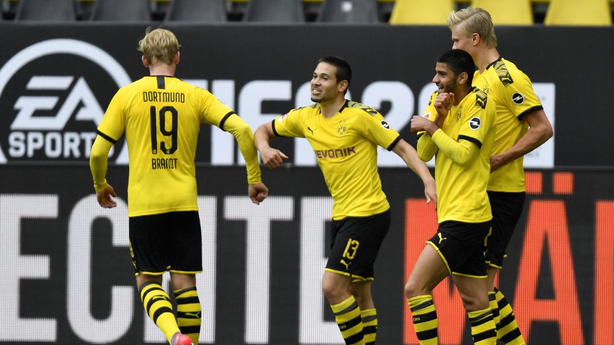Raphael Guerreiro of Borussia Dortmund (C) celebrates with team mate Julian Brandt (L) after scoring his side's second goal during the Bundesliga match between Borussia Dortmund and FC Schalke 04 at Signal Iduna Park on May 16, 2020 in Dortmund, Germany.