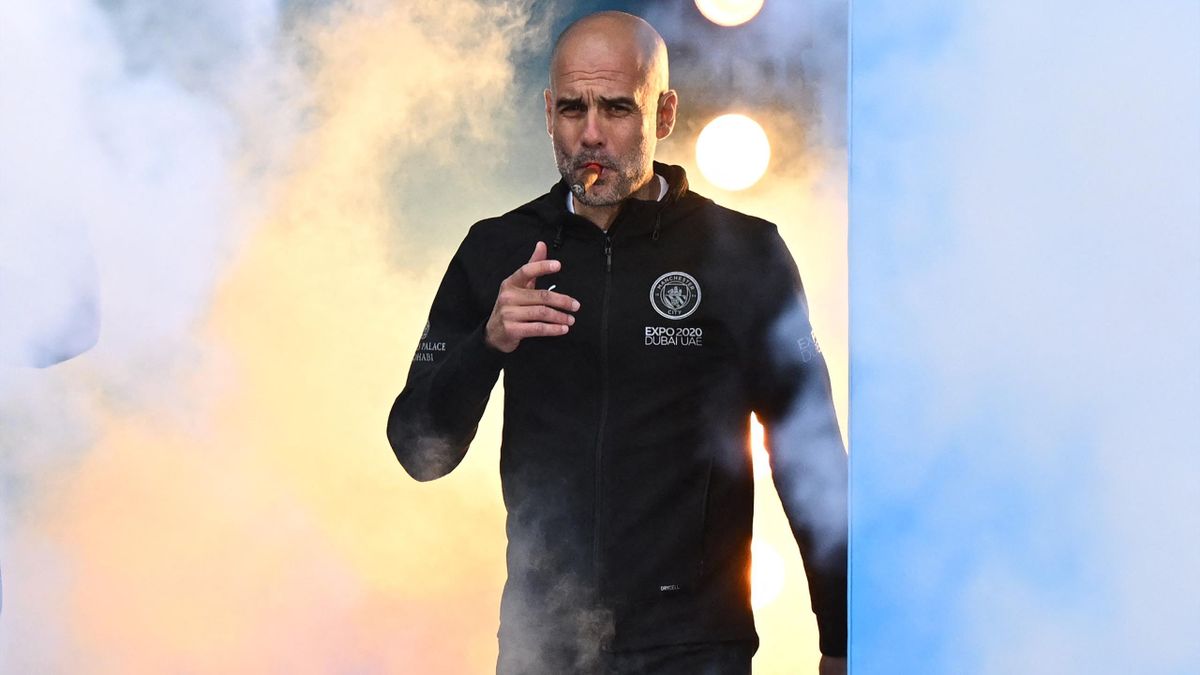 Manchester City's Spanish manager Pep Guardiola smokes a cigar as he attends an event for fans with members of the Manchester City football team following an open-top bus parade through Manchester