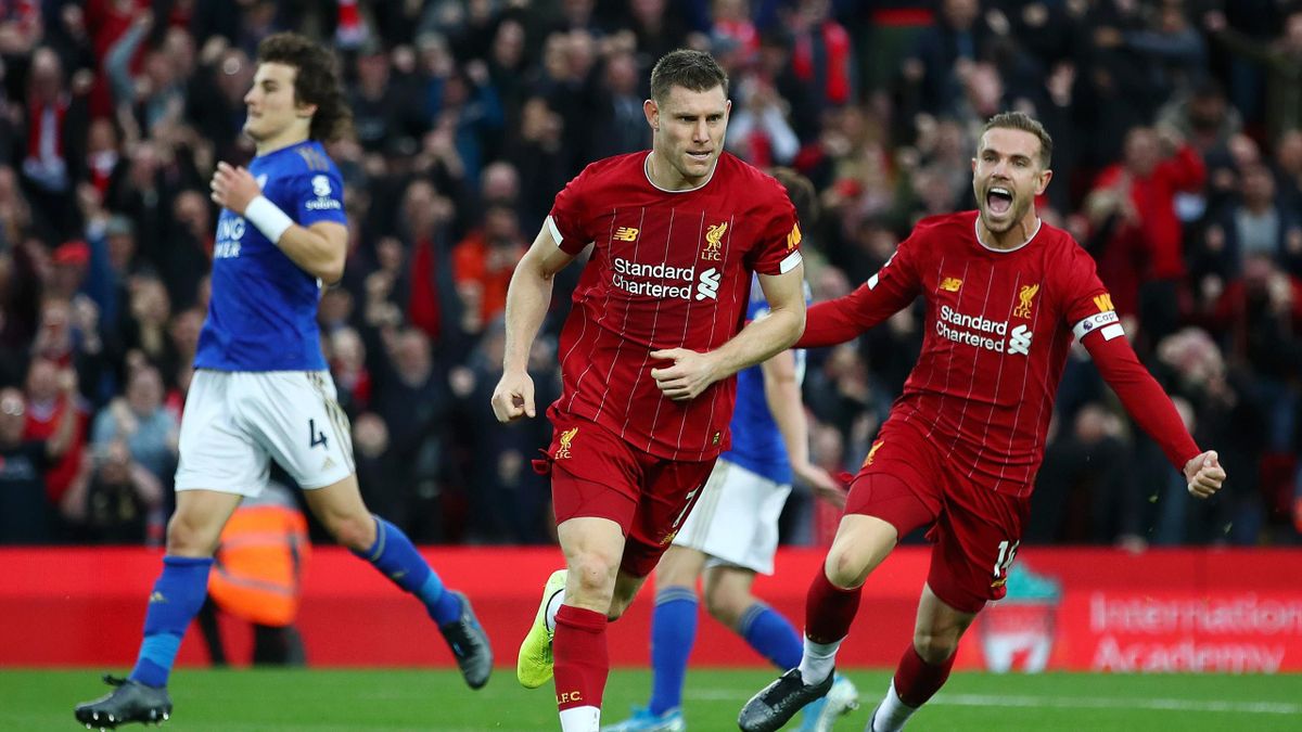 James Milner of Liverpool celebrates with Jordan Henderson of Liverpool and Divock Origi of Liverpool after he scores his sides second goal from the penalty spot during the Premier League match between Liverpool FC and Leicester City