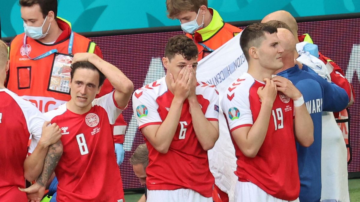 Denmark's players react as paramedics attend to Denmark's midfielder Christian Eriksen after he collapsed on the pitch during the UEFA EURO 2020 Group B football match between Denmark and Finland at the Parken Stadium
