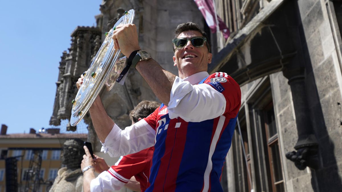 Robert Lewandowski of Bayern Muenchen holds up the championship trophy during the official Bundesliga championship celebration at the town hall at Marienplatz on May 15, 2022