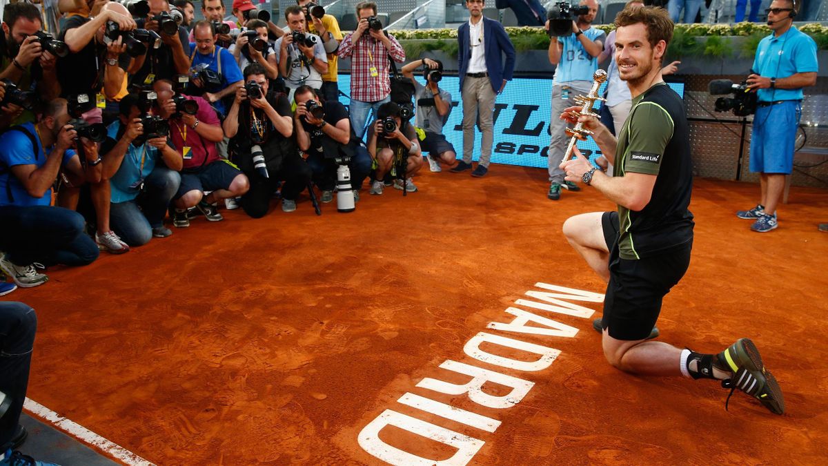 Andy Murray of Great Britain with the winners trophy by the court logo after his win over Rafael Nadal of Spain in the final during day nine of the Mutua Madrid Open tennis tournament at the Caja Magica on May 10, 2015 in Madrid, Spain.