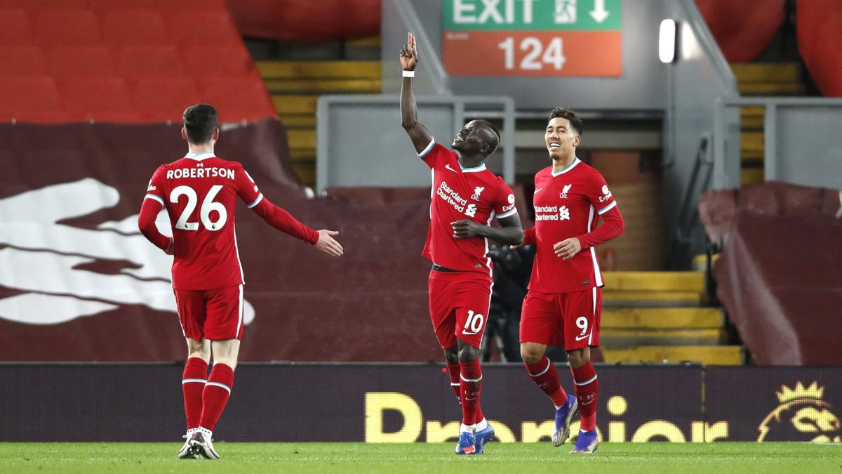 Sadio Mane of Liverpool celebrates with teammate Roberto Firmino and Andy Robertson after scoring their team's first goal during the Premier League match between Liverpool and West Bromwich Albion at Anfield