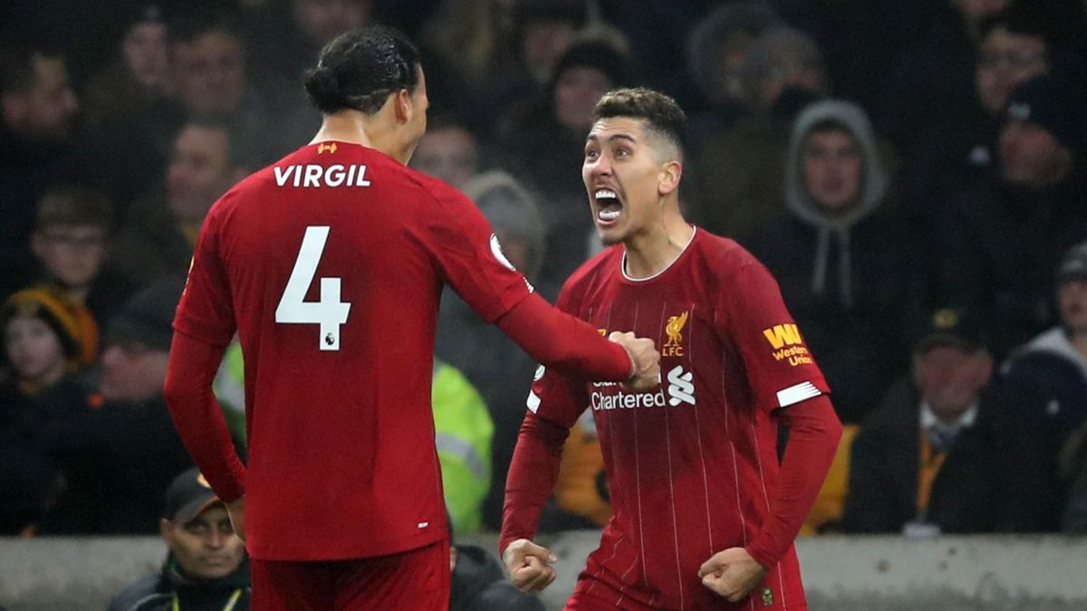 Roberto Firmino of Liverpool celebrates scoring their 2nd goal with Virgil van Dijk during the Premier League match between Wolverhampton Wanderers and Liverpool FC at Molineux on January 23, 2020 in Wolverhampton, United Kingdom.