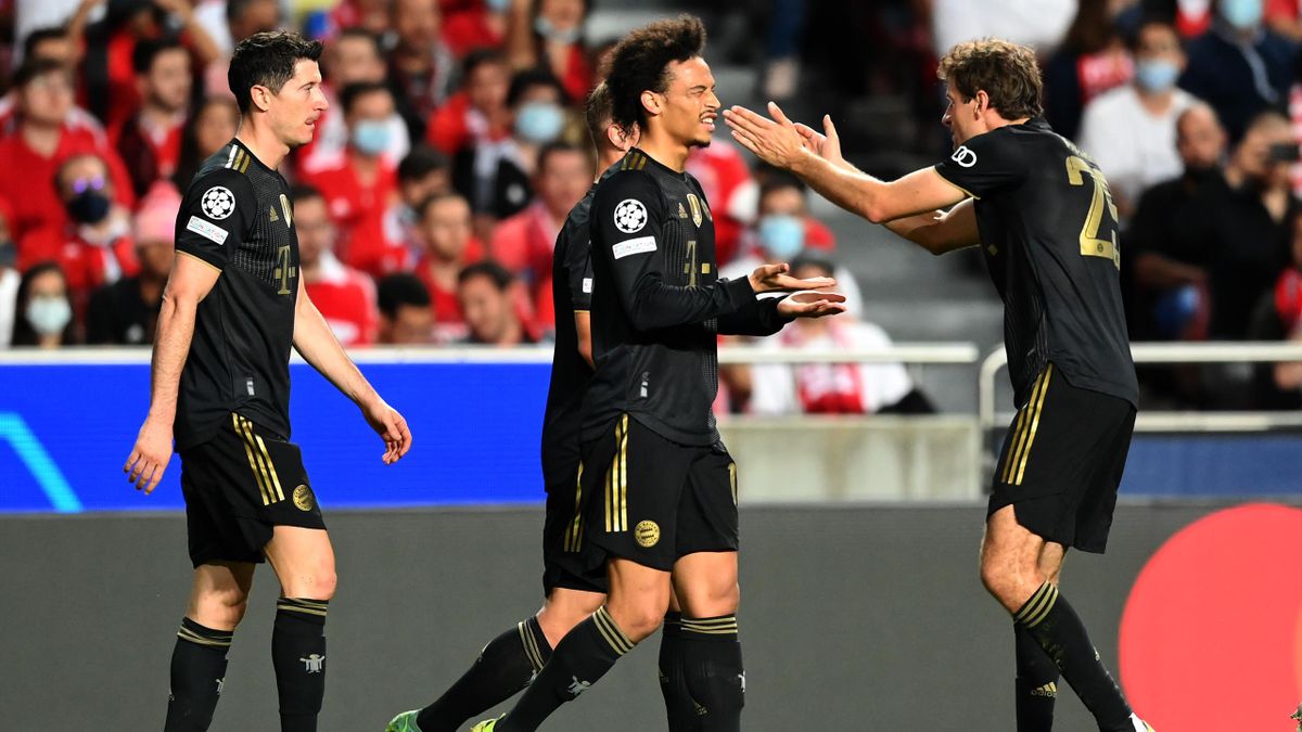 Leroy Sane of FC Bayern Muenchen celebrates with teammate Thomas Mueller after scoring their side's first goal during the UEFA Champions League group E match between SL Benfica and Bayern Muenchen at Estadio da Luz on October 20, 2021 in Lisbon, Portugal