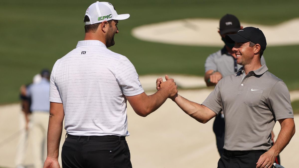 Jon Rahm of Spain greets Rory McIlroy of Northern Ireland on the range during a practice round prior to the Masters at Augusta National Golf Club on April 07, 2021 in Augusta, Georgia.