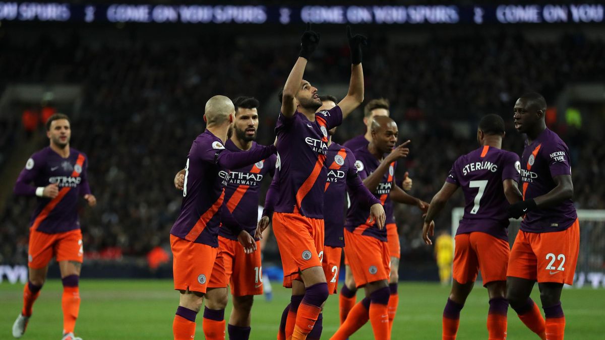 Riyad Mahrez of Manchester City celebrates with teammates after scoring his team's first goal during the Premier League match between Tottenham Hotspur and Manchester City at Wembley Stadium