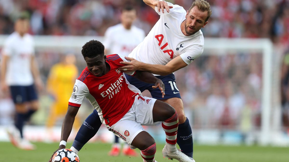 Bukayo Saka of Arsenal is challenged by Harry Kane of Tottenham Hotspur during the Premier League match between Arsenal and Tottenham Hotspur at Emirates Stadium on September 26, 2021