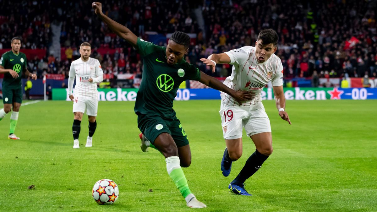 Ridle Baku of VfL Wolfsburg and Marcos Acuna of Sevilla FC battle for the ball during the UEFA Champions League group G match between Sevilla FC and VfL Wolfsburg at Estadio Ramon Sanchez Pizjuan on November 23, 2021 in Seville, Spain