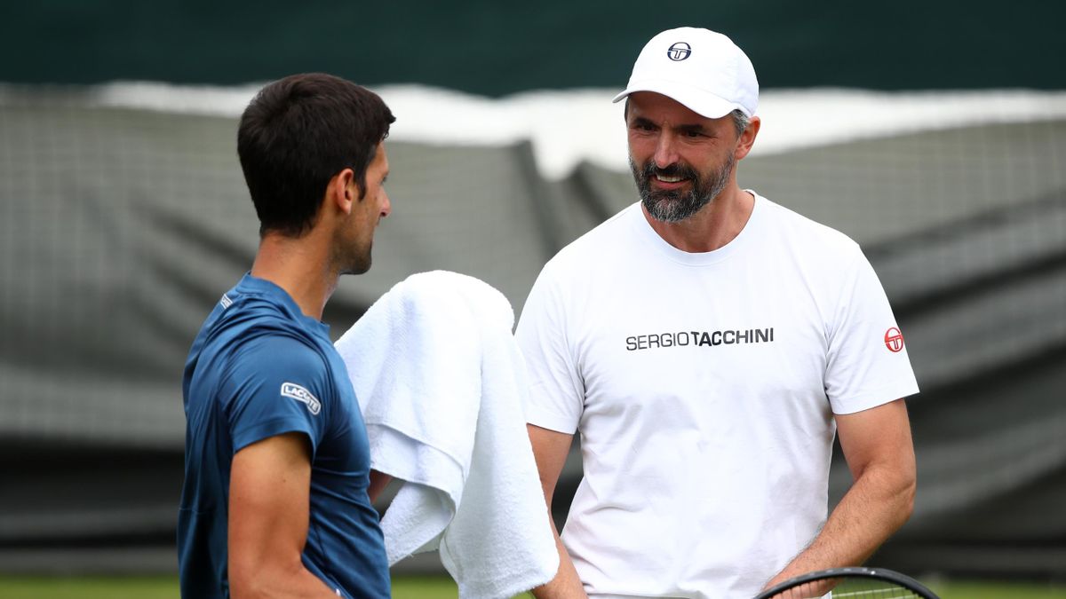 Novak Djokovic of Serbia (L) speaks with Goran Ivanisevic during a practice session at Wimbledon 2019