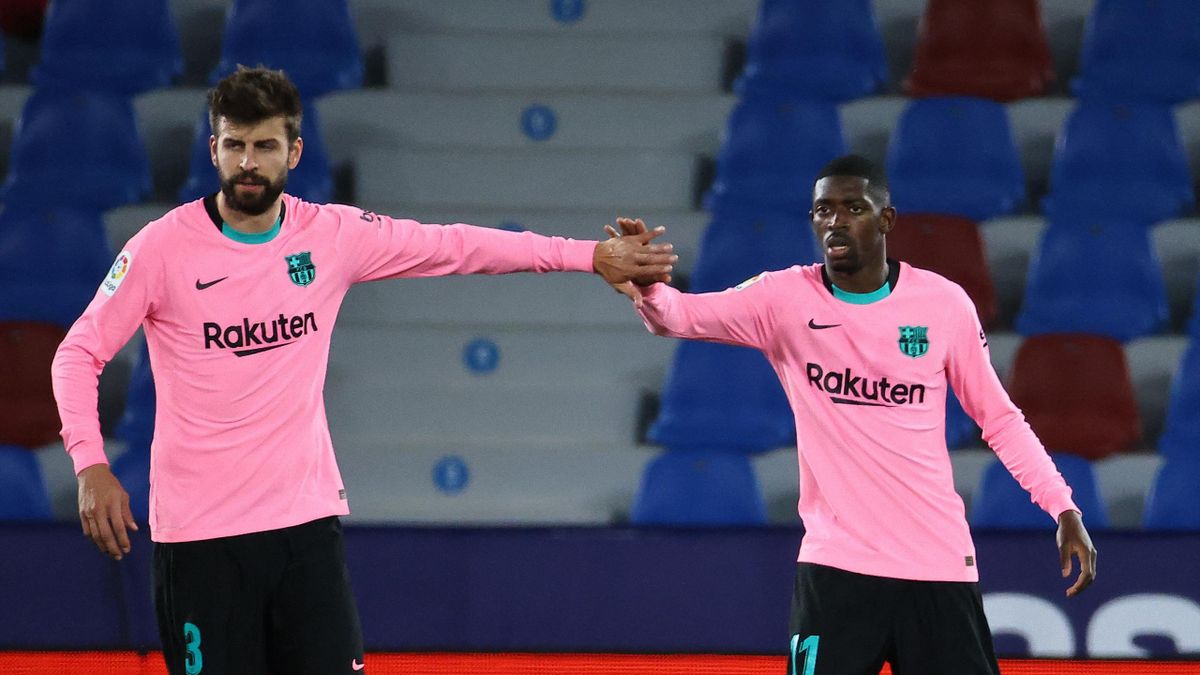 Barcelona's French forward Ousmane Dembele (R) celebrates with Barcelona's Spanish defender Gerard Pique after scoring during the Spanish league football match Levante UD against FC Barcelona at the Ciutat de Valencia stadium in Valencia on May 11, 2021