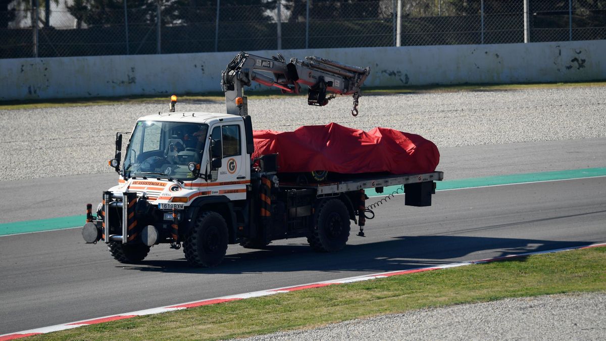 A truck carries the Ferrari of German driver Sebastian Vettel after he crashed into the barriers during the tests for the new Formula One Grand Prix season at the Circuit de Catalunya in Montmelo