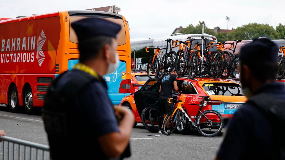A French policeman stands next to Bahrain Victorious cycling team's bus prior to the 18th stage of the 108th edition of the Tour de France cycling race, 129 km between Pau and Luz Ardiden, on July 15, 2021. - The Bahrain Victorious cycling team taking par