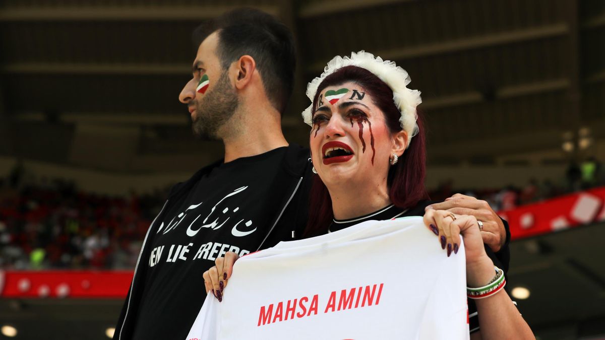 Twee dappere Iraanse fans protesteren op de tribune tegen de dood van Mahsa Amini.