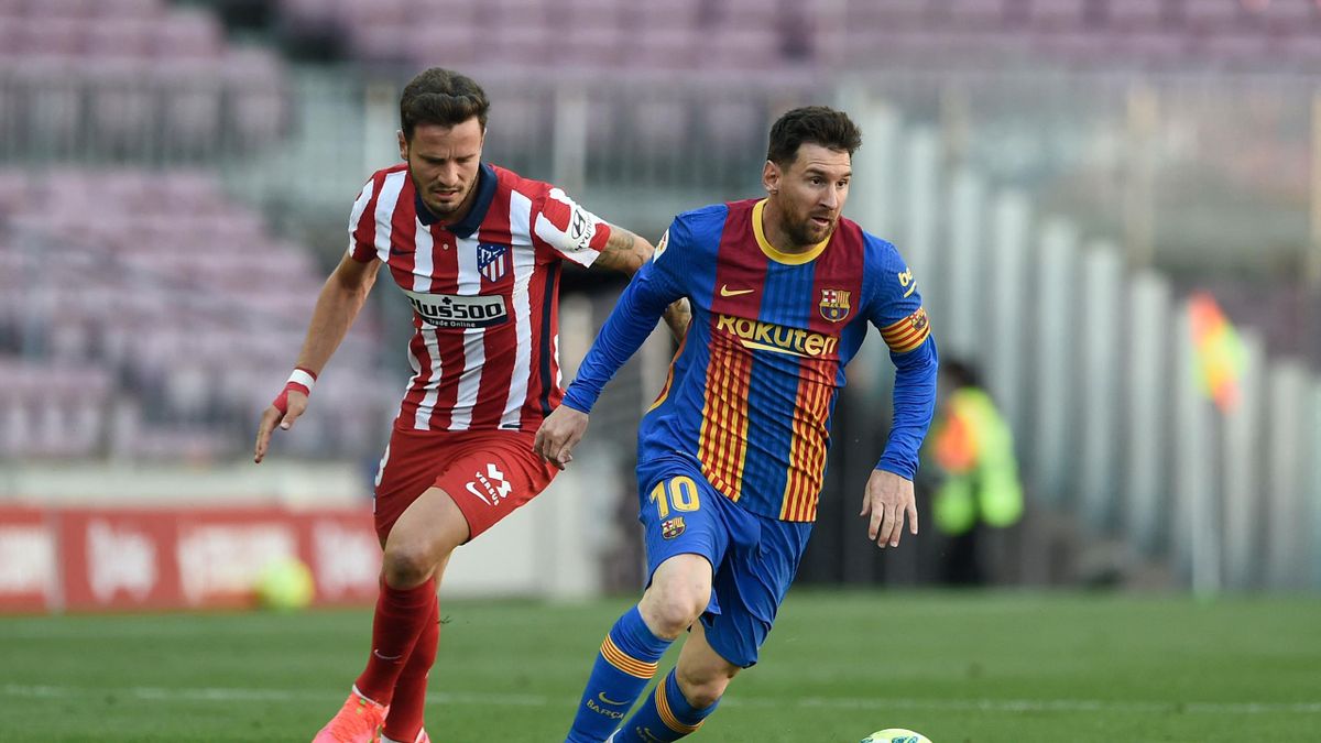 Atletico Madrid's Spanish midfielder Saul Niguez (L) challenges Barcelona's Argentinian forward Lionel Messi during the Spanish league football match FC Barcelona against Club Atletico de Madrid at the Camp Nou stadium in Barcelona on May 8, 2021.