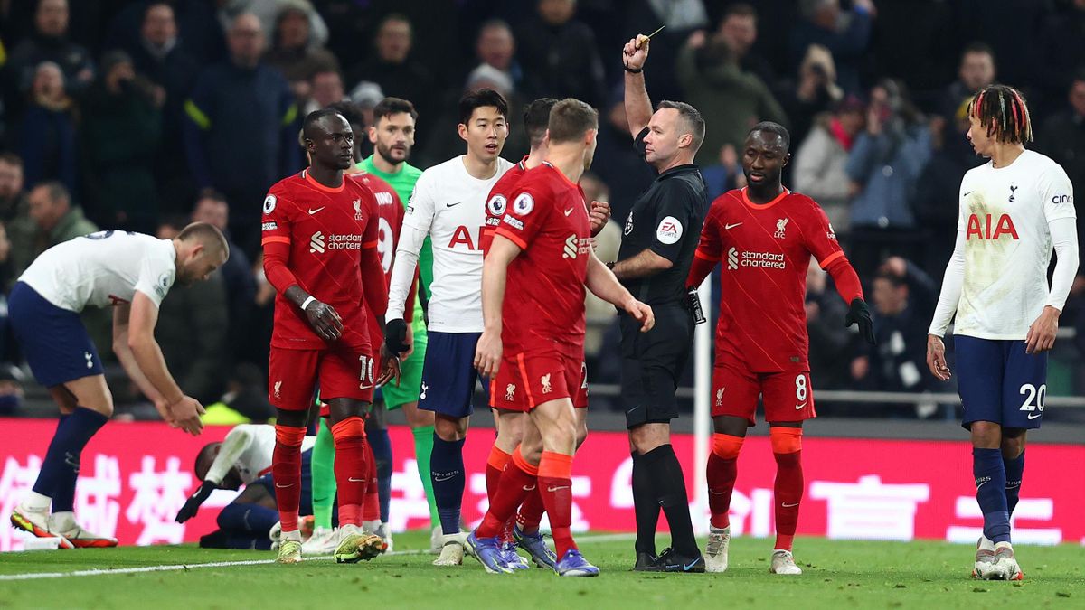 Referee Paul Tierney shows a yellow card to Andrew Robertson of Liverpool after a foul during the Premier League match between Tottenham Hotspur and Liverpool at Tottenham Hotspur Stadium on December 19, 2021 in London, England. (Photo by Julian Finney)