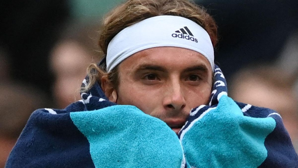 Greece's Stefanos Tsitsipas wraps himself in a towel during a pause in his men's singles tennis match against Australia's Nick Kyrgios on the sixth day of the 2022 Wimbledon Championships at The All England Tennis Club in Wimbledon, southwest London, on J