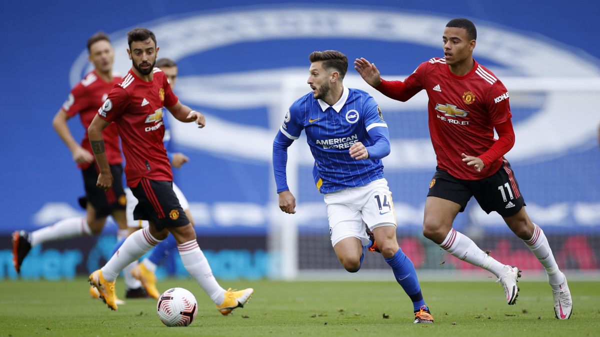 Adam Lallana of Brighton and Hove Albion is challenged by Mason Greenwood of Manchester United
