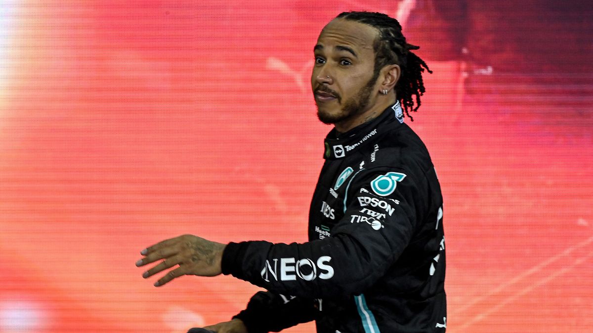 Second-placed Mercedes' British driver Lewis Hamilton reacts on the podium of the Yas Marina Circuit after the Abu Dhabi Formula One Grand Prix on December 12, 2021. - Max Verstappen became the first Dutchman ever to win the Formula One world championship