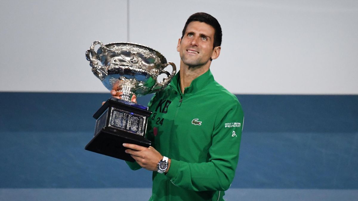 Serbia's Novak Djokovic holds the Norman Brookes Challenge Cup trophy after beating Austria's Dominic Thiem in their men's singles final match on day fourteen of the Australian Open tennis tournament in Melbourne on February 3, 2020.