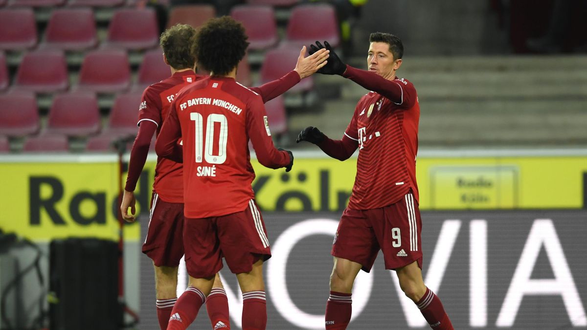 Robert Lewandowski of FC Bayern Muenchen celebrates with teammates after scoring their side's third goal during the Bundesliga match between 1. FC Köln and FC Bayern München at RheinEnergieStadion on January 15, 2022 in Cologne, Germany.