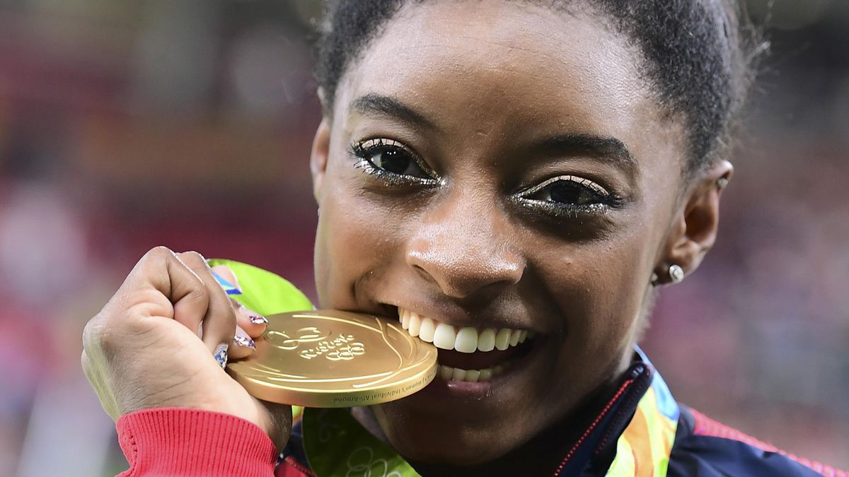 US gymnast Simone Biles celebrates with her gold medal after the women's individual all-around final of the Artistic Gymnastics at the Olympic Arena during the Rio 2016 Olympic Games in Rio de Janeiro on August 11, 2016. US