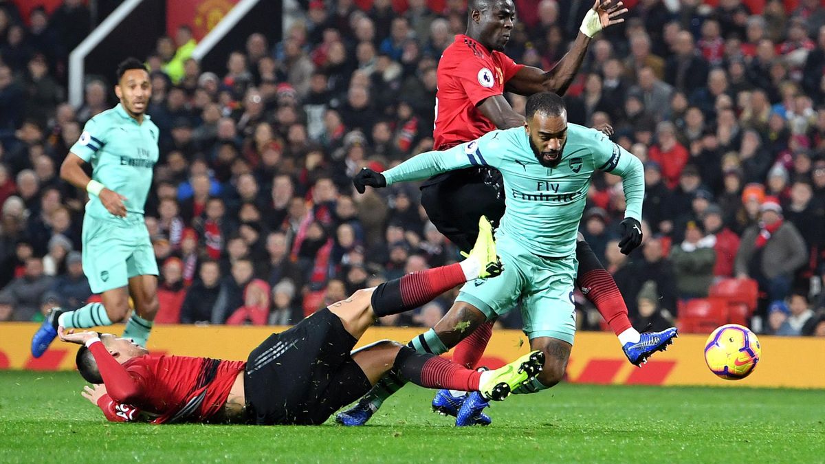 Alexandre Lacazette of Arsenal scores his team's second goal as he is challenged by Marcos Rojo of Manchester United during the Premier League match between Manchester United and Arsenal FC at Old Trafford on December 5, 2018 in Manchester, United Kingdom