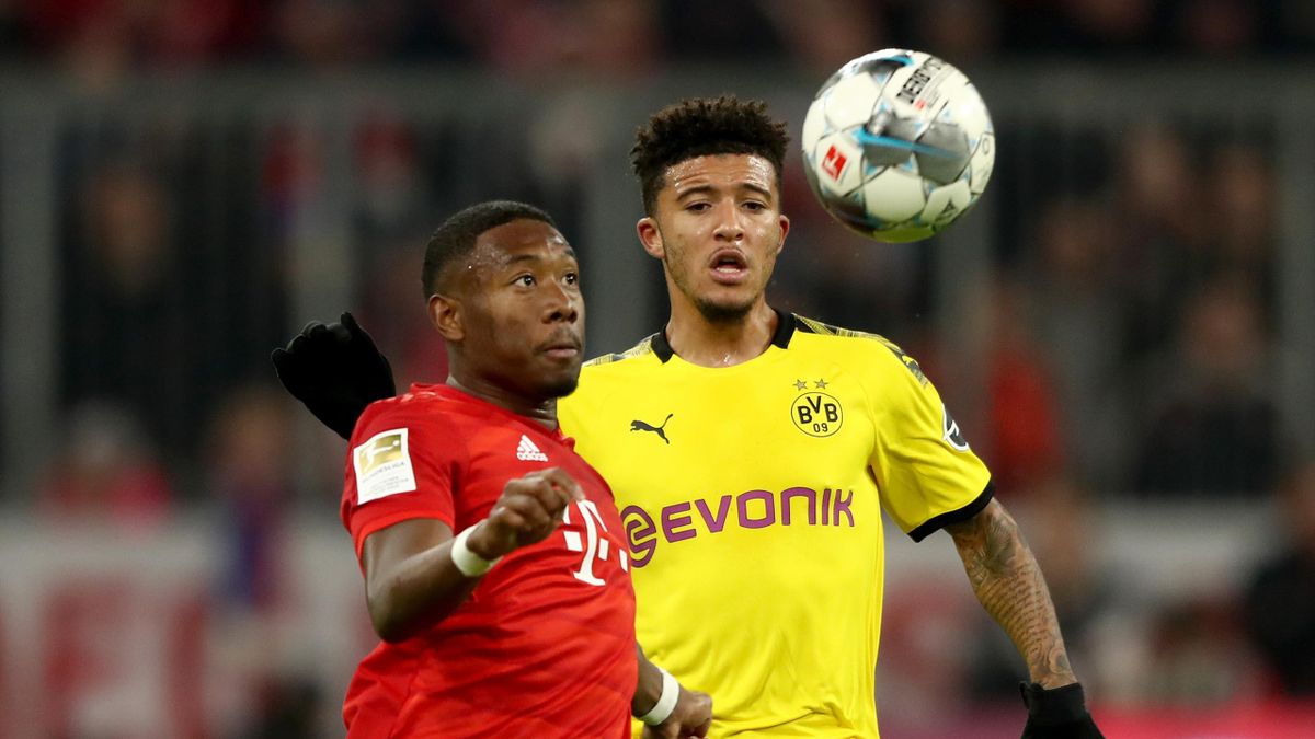avid Alaba (L) of FC Bayern Muenchen battles for the ball with Jadon Sancho of Dortmund during the Bundesliga match between FC Bayern Muenchen and Borussia Dortmund at Allianz Arena on November 09, 2019 in Munich, Germany