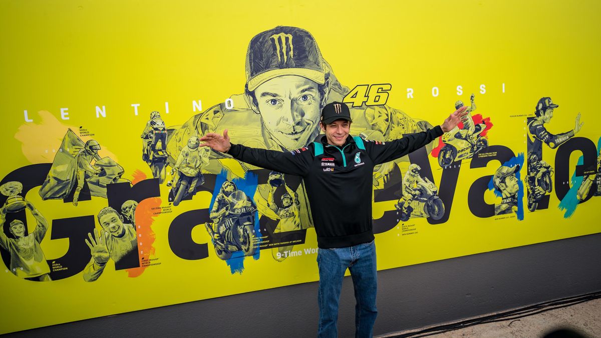 Valentino Rossi posa davanti al poster dedicato alla sua carriera