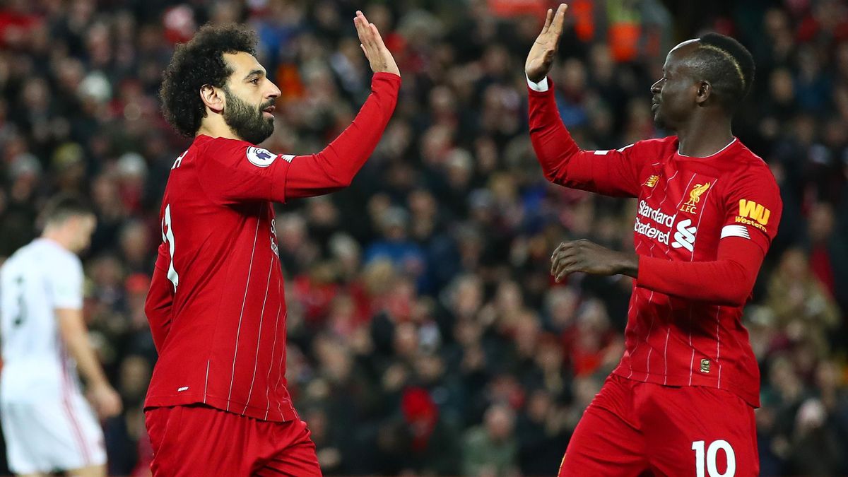 Mohamed Salah of Liverpool celebrates with Sadio Mane after scoring his team's first goal during the Premier League match between Liverpool FC and Sheffield United at Anfield on January 02, 2020