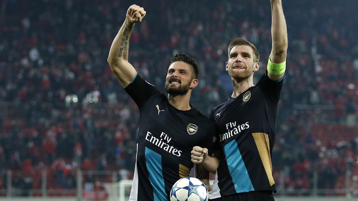 Arsenal's Olivier Giroud celebrates with the matchball and Per Mertesacker after scoring a hat trick at the end of the match.